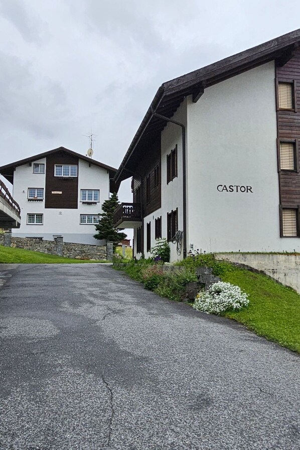 En byggnad med namnet ”CASTOR” på fasaden, en asfalterad uppfart och en stenmur.