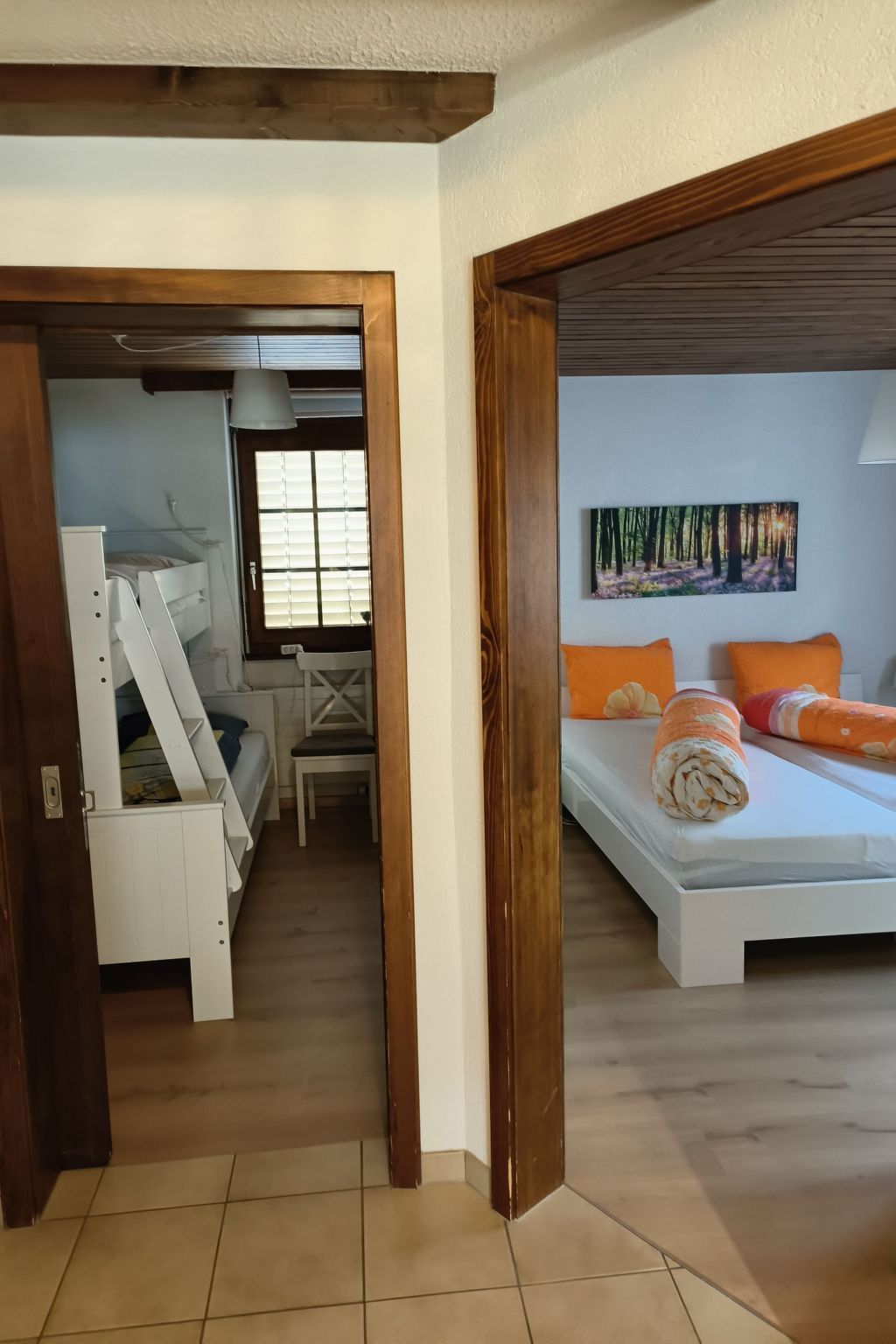 Une chambre à coucher avec un lit, des oreillers, une fenêtre et un tableau accroché au mur.