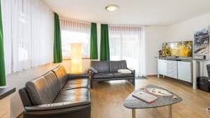 A modern living room with a leather sofa, a small coffee table, and a television on a stand. - AsterB, (Grächen), by Interhome (Grächen)