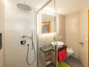 A modern bathroom with a glass shower enclosure, a sink, and a toilet. - Stella del Cervino, (Grächen), 2144 by Interhome (Grächen)