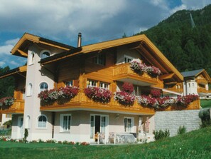 A multi-story wooden house with balconies, a chimney, and flower boxes. - Stella del Cervino, (Grächen), 2144 by Interhome (Grächen)