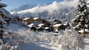 A snow-covered mountain village with wooden chalets, a clear sky, and snow-laden trees. - Soldanella, (Grächen), by Interhome (Grächen)