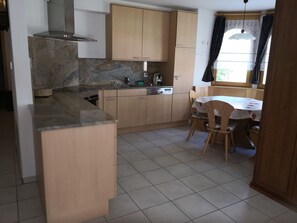 Una cucina compatta con piano cottura integrato, lavello e mobili in legno.