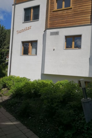 Un edificio con la scritta 'Sunstar' sulla facciata, caratterizzato da un esterno bianco e piani superiori in legno.