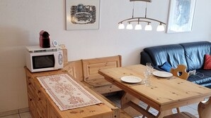 A compact living space with a kitchenette, a dining area, and a seating area. - Metropol B19, (Grächen), 1079 by Interhome (Grächen)