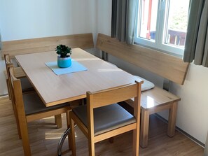 A dining area with a wooden table and bench seating. - Chalet Heimatglück, (Grächen), 1179 - 1181 by Interhome (Grächen)