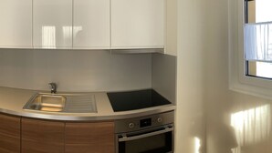 A kitchen with a stainless steel sink, oven, and wooden cabinets. - Soldanella, (Grächen), by Interhome (Grächen)