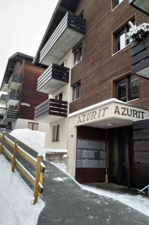 A modern building with a sign reading 'AZURIT' and a wooden fence in front. - Ferienwohnunung Nr.22,Haus Azurit, (Grächen), 1201 by Interhome (Grächen)
