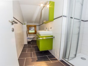 Ein Badezimmer mit Dusche, Toilette und Waschbecken.