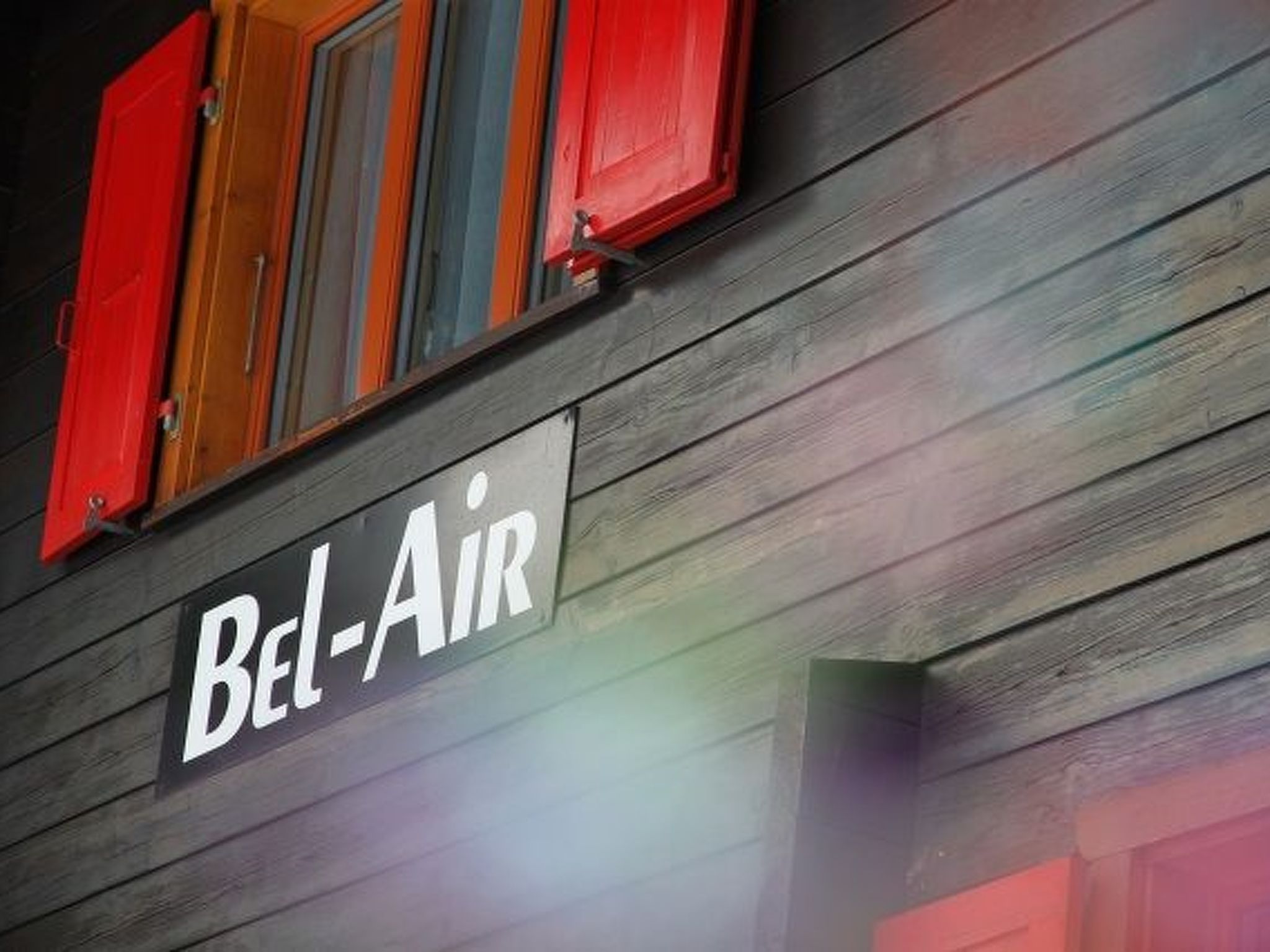 A building facade with a sign reading 'Bel-Air' and wooden siding.