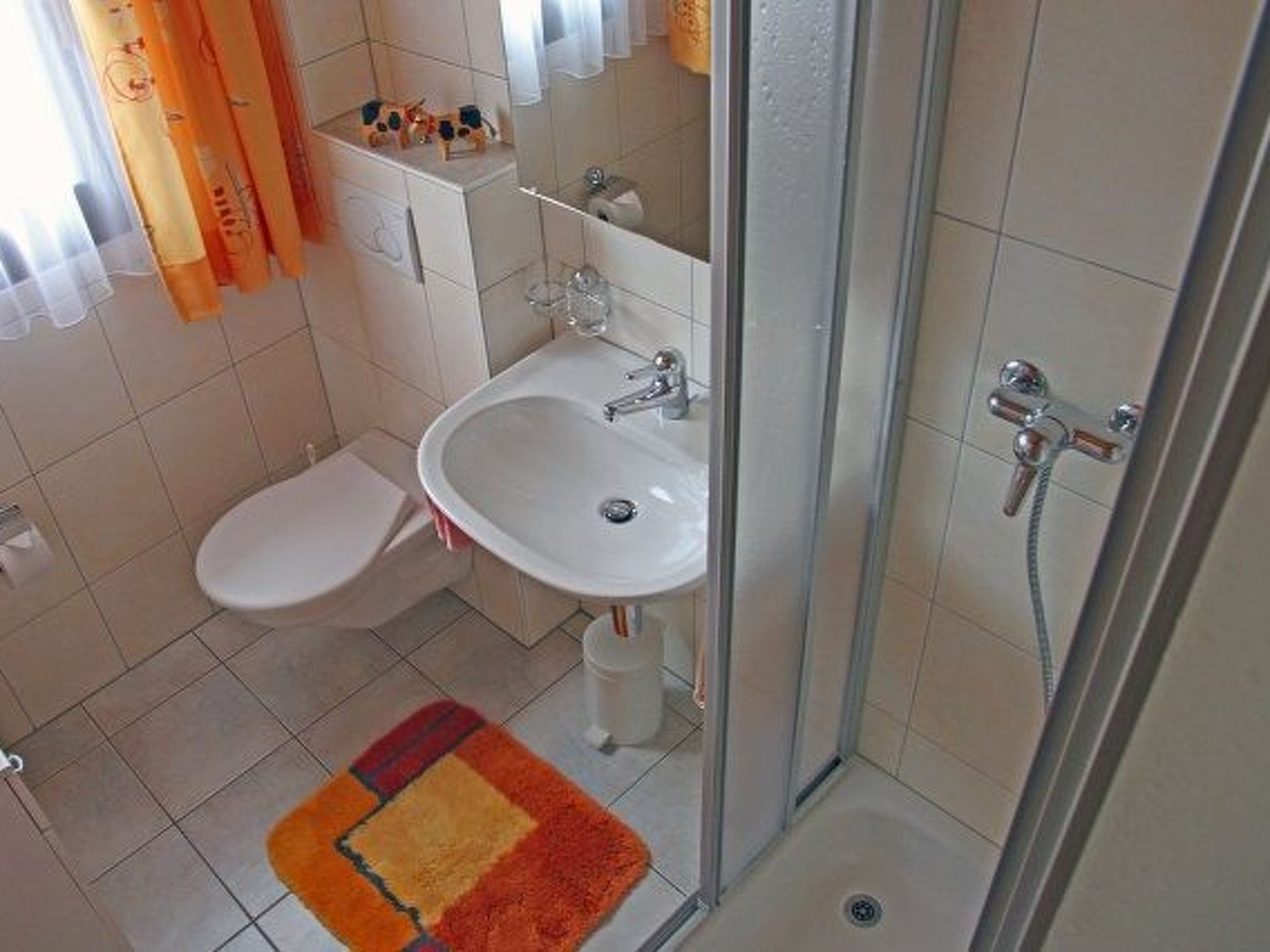 A bathroom with a toilet, sink, and shower.