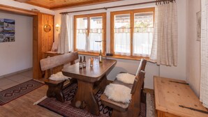 A wooden dining table with benches, a rug, and a wooden cabinet. - Dominique, (Grächen), 1013 by Interhome (Grächen)