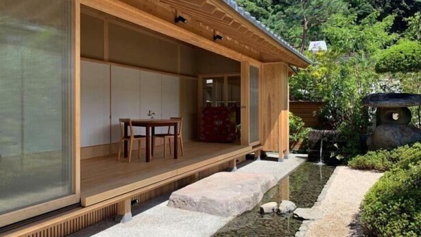 A traditional Japanese-style building with a wooden exterior, a sliding door, and a small outdoor seating area. - Hogetsu (Kagoshima)
