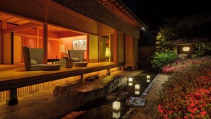 Un bâtiment de style japonais traditionnel, doté d’un sol recouvert de tatamis, d’une terrasse en bois et d’un bassin à carpes koï.