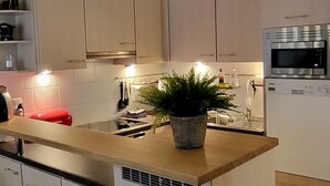 A modern kitchen with a central island, stainless steel appliances, and a potted plant. - Silberblick, (Grächen), by Interhome (Grächen)