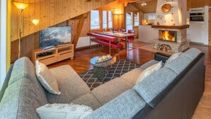 Una sala de estar amplia con un sofá grande, un televisor de pantalla plana y una chimenea.