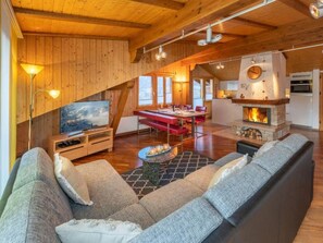 A spacious living room with a large sofa, a flat-screen TV, and a fireplace. - Pumuckl, (Grächen), 2060 by Interhome (Grächen)