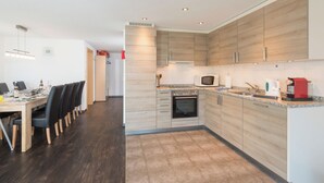 Una cucina moderna con mobili in legno, un forno a microonde e una macchina per il caffè.