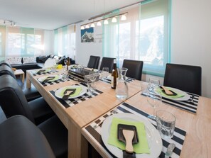 A dining area with a long table set for four, equipped with plates, cutlery, and glasses. - Ferienwohnungen Clarino, AZapartments.ch, B&B, (Grächen), 1285 by Interhome (Grächen)