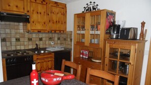 Una cocina con armarios de madera, una estufa y una mesa con un letrero que dice 'GRACHAEN'.