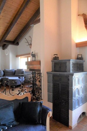 Uma sala de estar aconchegante com lareira, um sofá e um veado decorativo na parede.