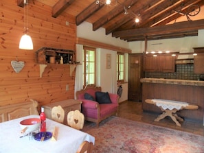 Ein gemütliches Blockhaus-Interieur mit Essbereich, einer Couch und einer Küche.