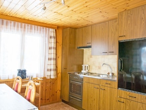 Eine Küche mit Holzwänden, einem Herd, einer Spüle und einem Kühlschrank.