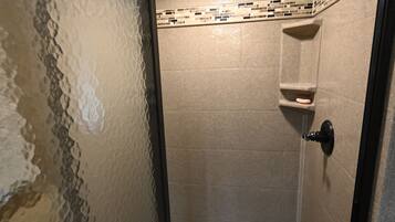 Regadera, secadora de cabello, toallas, papel de baño