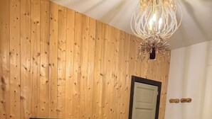 A room with two single beds, a wooden headboard, a chandelier, a door, and a small table. - Viale del Re 33: A Summer Fairy Tale Between the Sea and the Theater (Reggio Calabria)