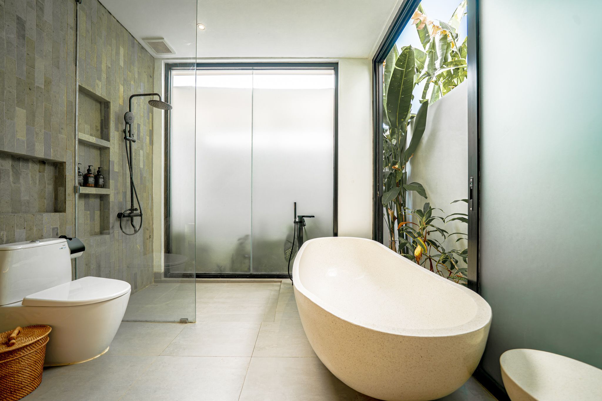 Un baño moderno con una bañera independiente, cabina de ducha con mampara de vidrio y un inodoro.