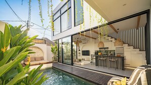 Een modern huis met een zwembad, een terras en een keukenhoek.