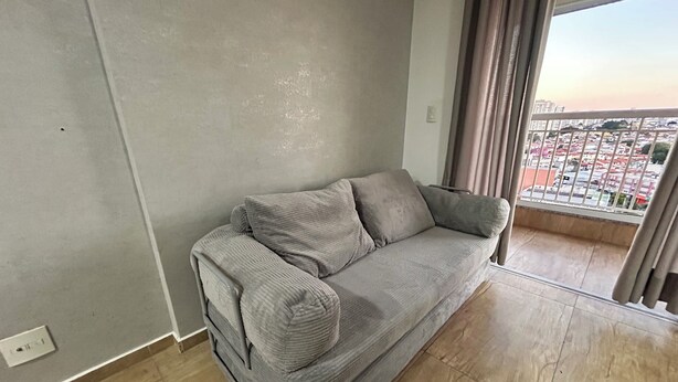 Un divano grigio in una stanza con vista su un balcone.