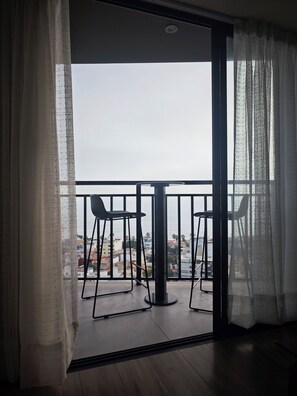 A balcony with two chairs and a table, overlooking a cityscape. - Romance and comfort with a terrace and a view of the sea., (San Isidro)