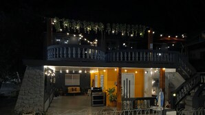 Una casa a due piani con un balcone, una scala e un cancello.