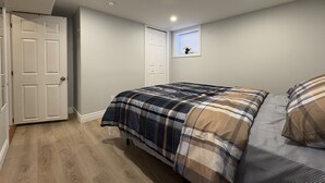 Una camera da letto con un letto, una finestra, una porta e una luce a soffitto.
