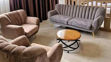 A living room with a sofa, armchairs, and a coffee table.