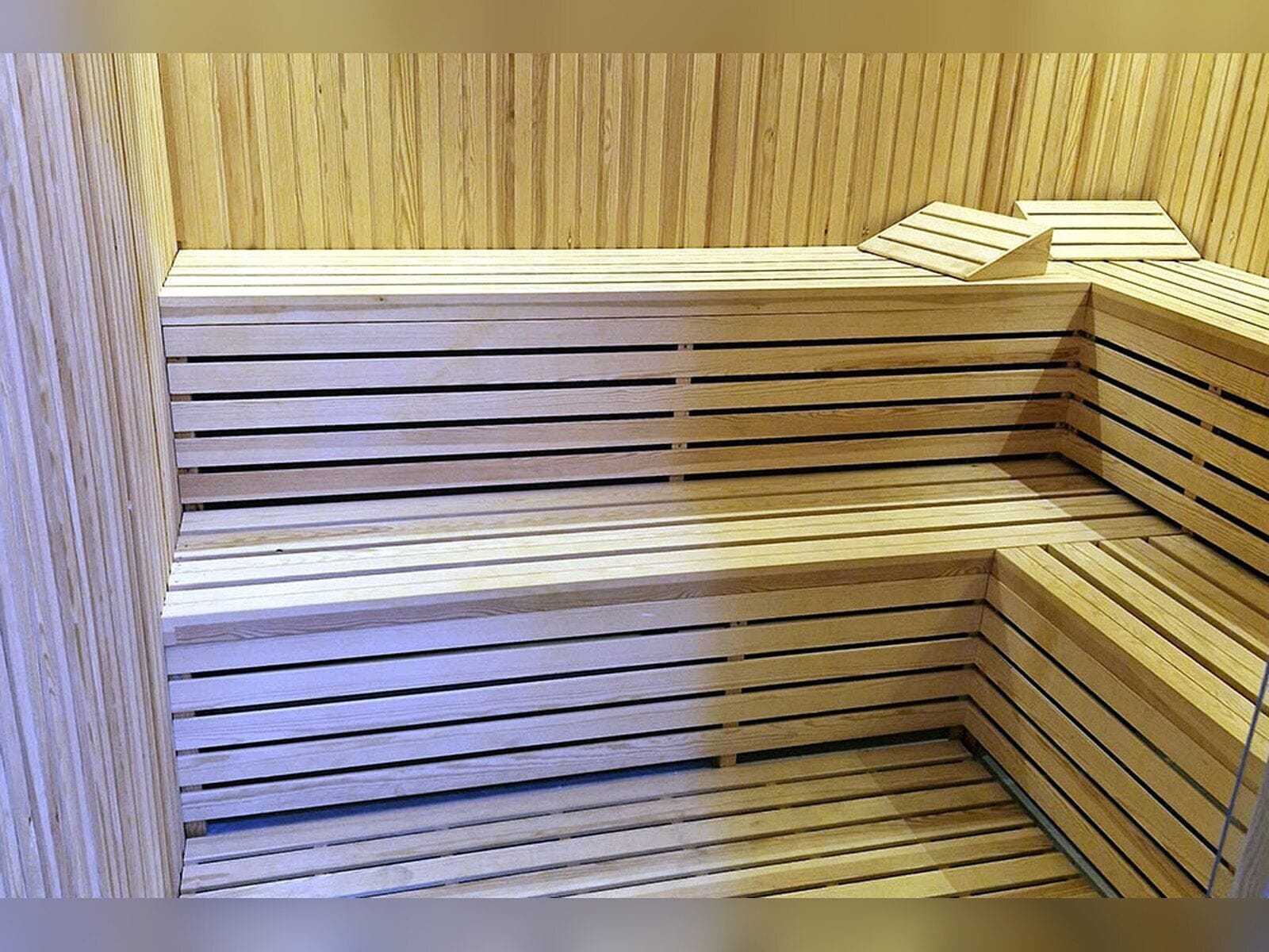 Una estructura moderna de madera, de varios niveles y con listones horizontales, probablemente una sauna o baño de vapor.