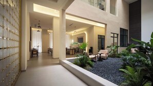 Un espacio interior amplio con comedor, asientos y un pequeño jardín con plantas.