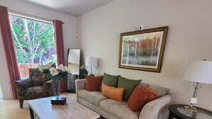 Ein Wohnzimmer mit einer Couch, einem Couchtisch und einem Gemälde an der Wand.