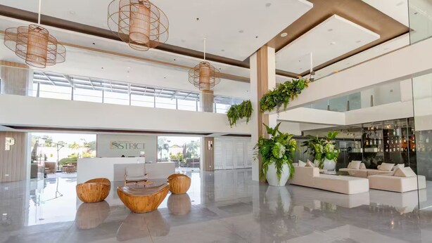 Eine großzügige Lobby mit einer Rezeption, modernen Möbeln und großen Fenstern.
