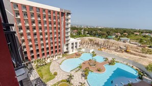 Ein Hotel mit mehreren Etagen, einem großen Schwimmbad und Blick auf die Umgebung.