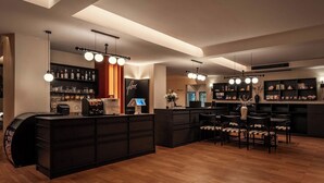 Um lobby de hotel moderno com balcão de recepção, área de estar e bar.