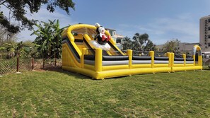 A large inflatable slide structure in a grassy area with a building in the background. - YEMEI Art Villas (Beihai)