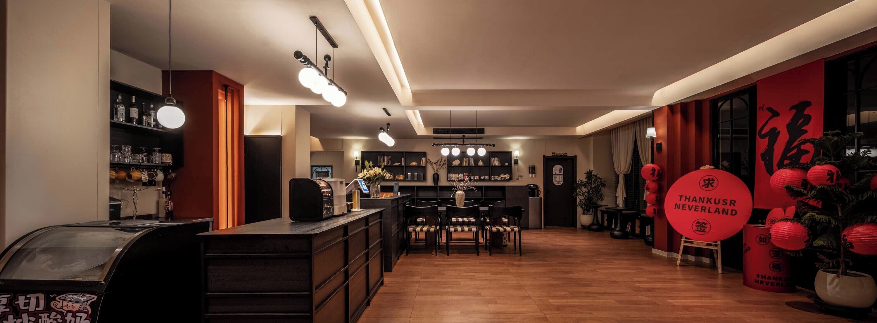 A modern interior with a bar area, seating, and a display of red lanterns.