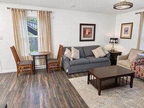 A living room with a sofa, a dining table with chairs, a coffee table, and a lamp. - Spacious 2BR/2BA Home in EaDo Houston – Full Kitchen, W/D, Near Downtown (Houston)