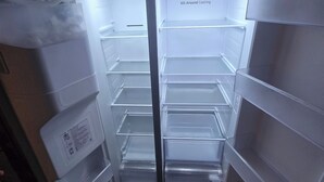 Insidan av ett kylskåp med flera hyllor och ett frysfack.