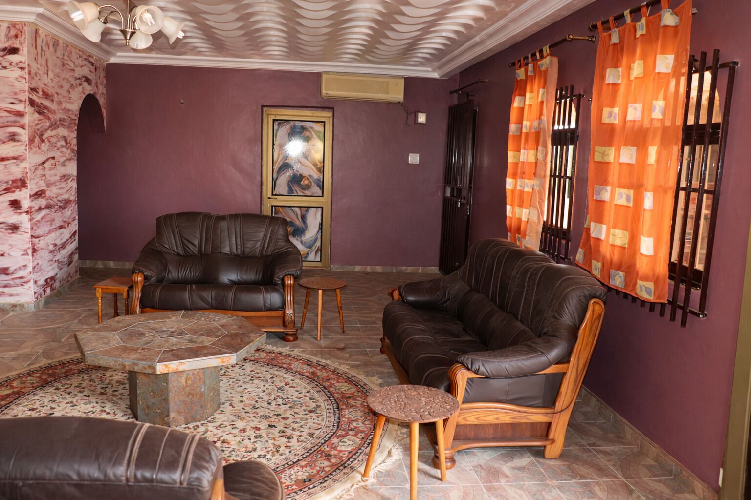 A living room with two leather sofas, a coffee table, and a patterned rug.