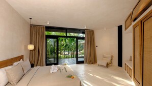 Een hotelkamer met een bed, een stoel, een groot raam en uitzicht op groen.