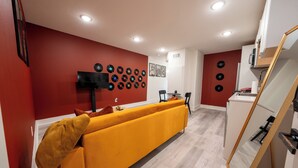 Un soggiorno moderno con un divano, una TV a schermo piatto e una parete decorata con dischi in vinile.