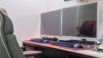 A computer desk with two monitors, a keyboard, a mouse, and a chair.